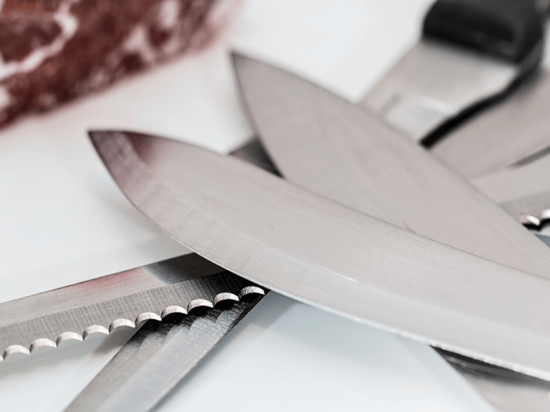 how to maintain a sharp knife
Serrated knife with multiple kitchen knives placed on top of each other